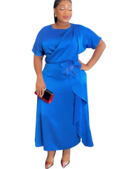 A woman wears a royal blue midi dress with short sleeves, a draped waist, and a floral accent.