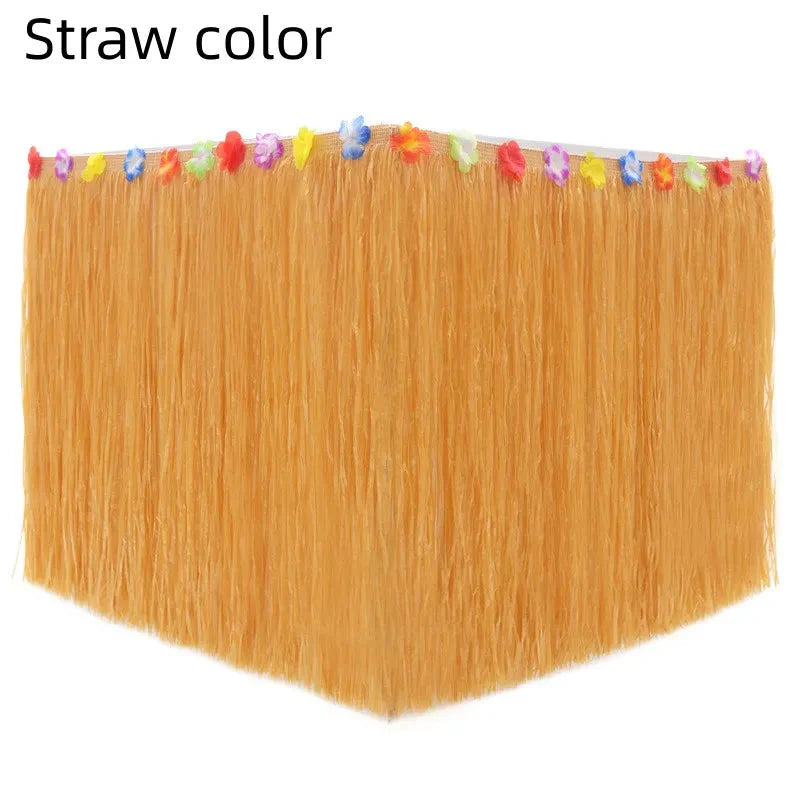 Hawaiian grass table skirt for tropical party decor, shown draped on a table with lush greenery and tropical accents.