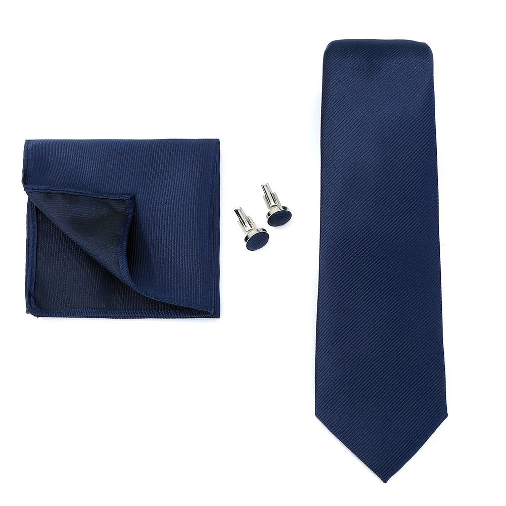 Solid color men's formal wedding necktie with jacquard woven pattern, matching handkerchief, and cufflinks on a business suit.