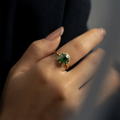 A gold-toned sterling silver ring featuring a large square green zircon surrounded by small stones.