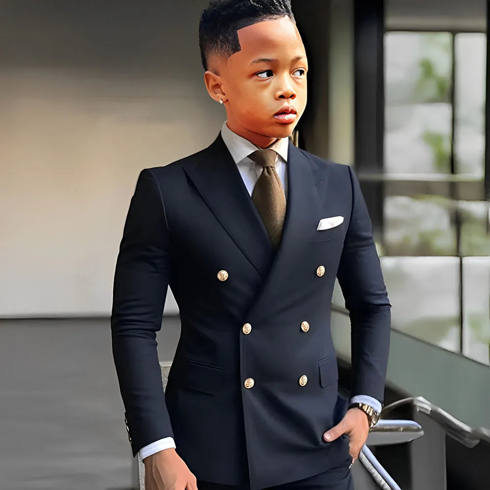 Navy blue solid boy's tuxedo with peak lapel, double-breasted jacket, tailored for formal weddings and special occasions.