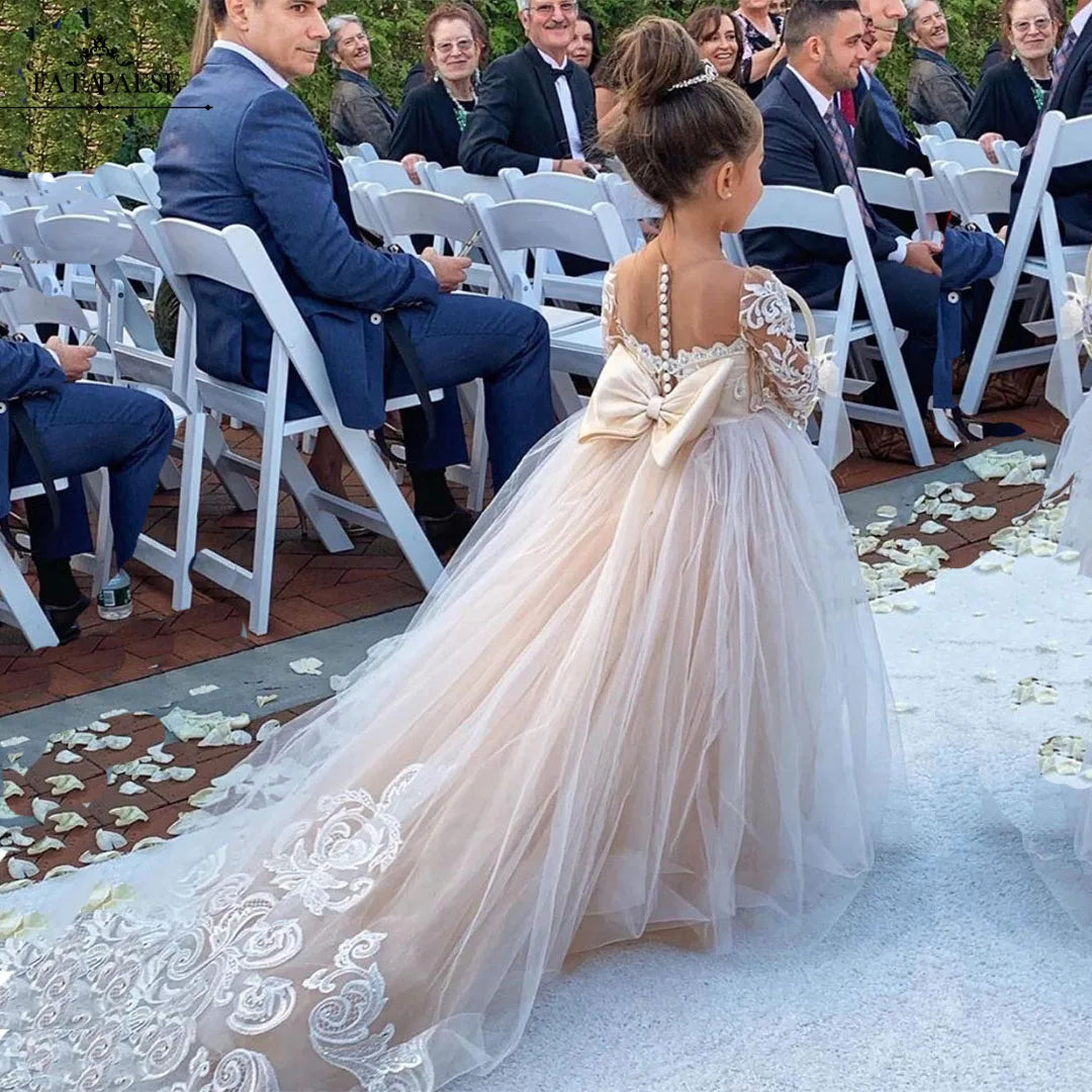 White lace flower girl dress by Showlu Fashion Store featuring long sleeves and a tulle ball gown design.