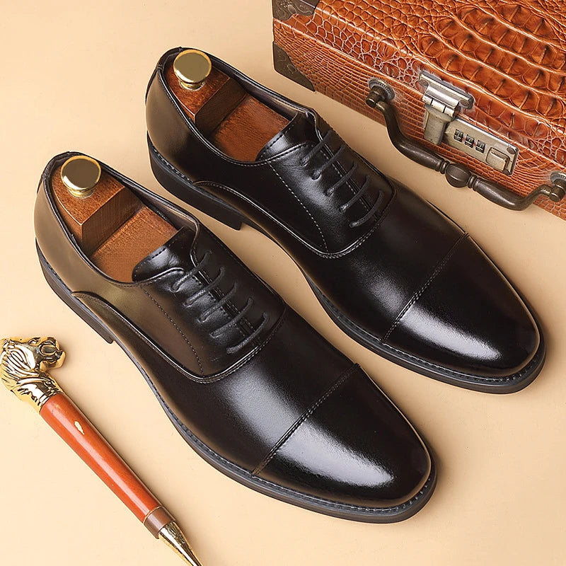 Men's black genuine leather dress shoes with cap toe and lace-up design, suitable for business, formal, or wedding occasions.