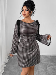 A woman wears a black and white gingham print long-sleeve dress with shoulder tie details.