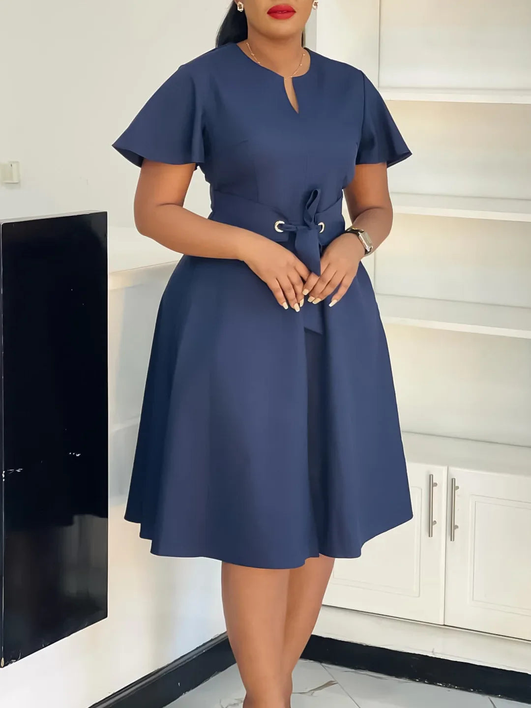A navy blue knee-length A-line dress with short sleeves, a notched neckline, and a waist tie.