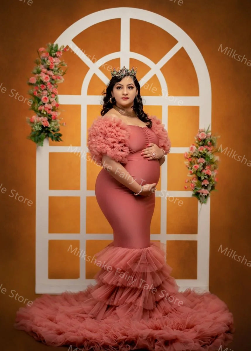 Pink off-shoulder maternity robe with tiered ruffles, mermaid silhouette, sweep train, perfect for pregnancy and baby shower photos.