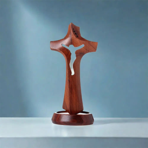 Wooden hollow cross sculpture with natural finish, standing on a base, vintage religious ornament, crucifix sculpture for desktop display.