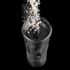A portable electric protein shaker cup with a black base and a clear container filled with water.