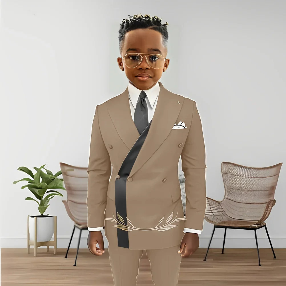 Boy wearing Showlu Fashion Store double-breasted blazer and pants set, stylish kids' wedding tuxedo for ages 2 to 16.