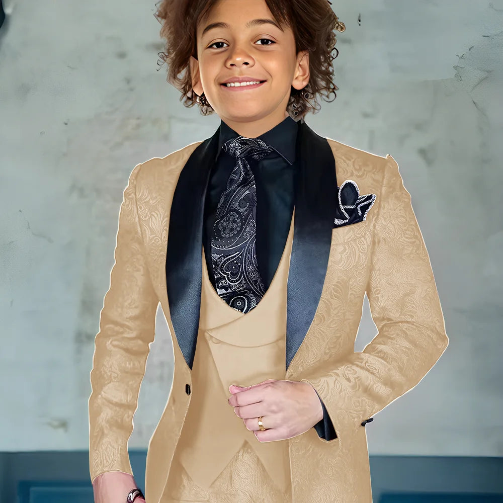 Burgundy jacquard boys' three-piece suit with jacket, pants, and vest, formal tuxedo style for weddings and special occasions.