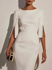 A white midi dress with a round neck, half sleeves featuring beaded slits, and a slim fit.