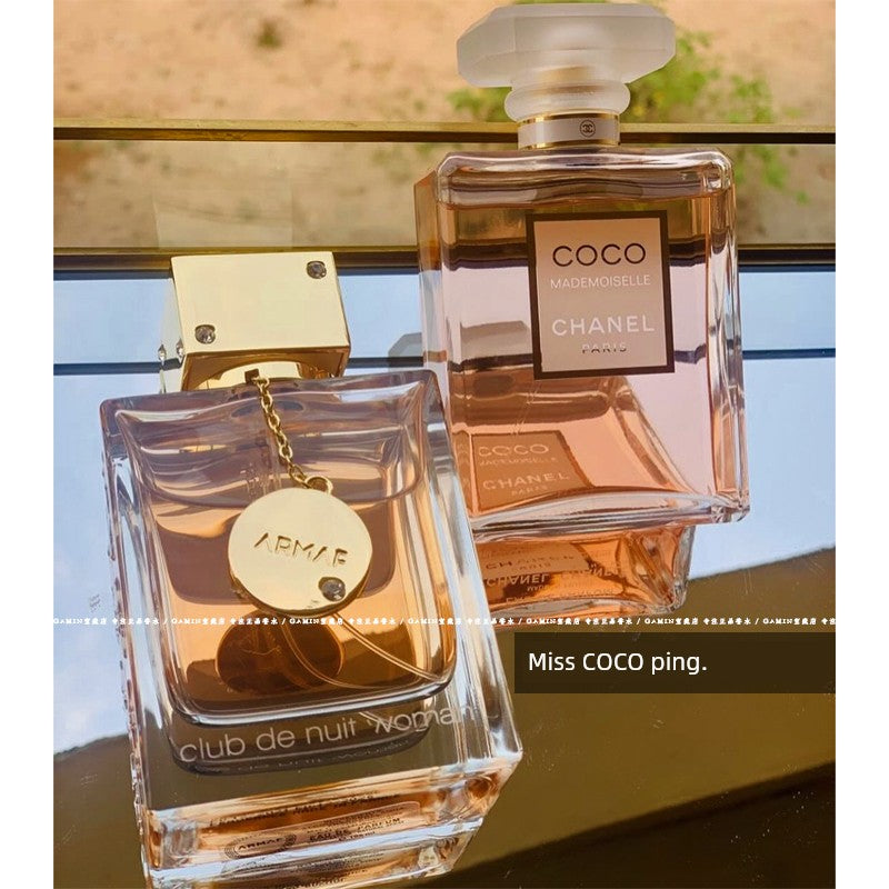 Fruity floral perfume sample of Armaf Club de Nuit Woman EDP, showcasing the elegant bottle with a pink and purple design.