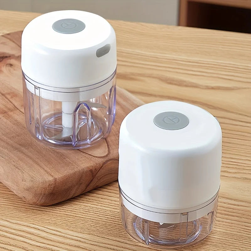 Mini rechargeable garlic chopper and meat grinder in black, showing the compact device with stainless steel blades for crushing garlic and nuts