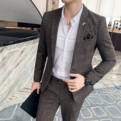 A man wears a brown plaid two-piece suit with a white button-down shirt and a pocket square.