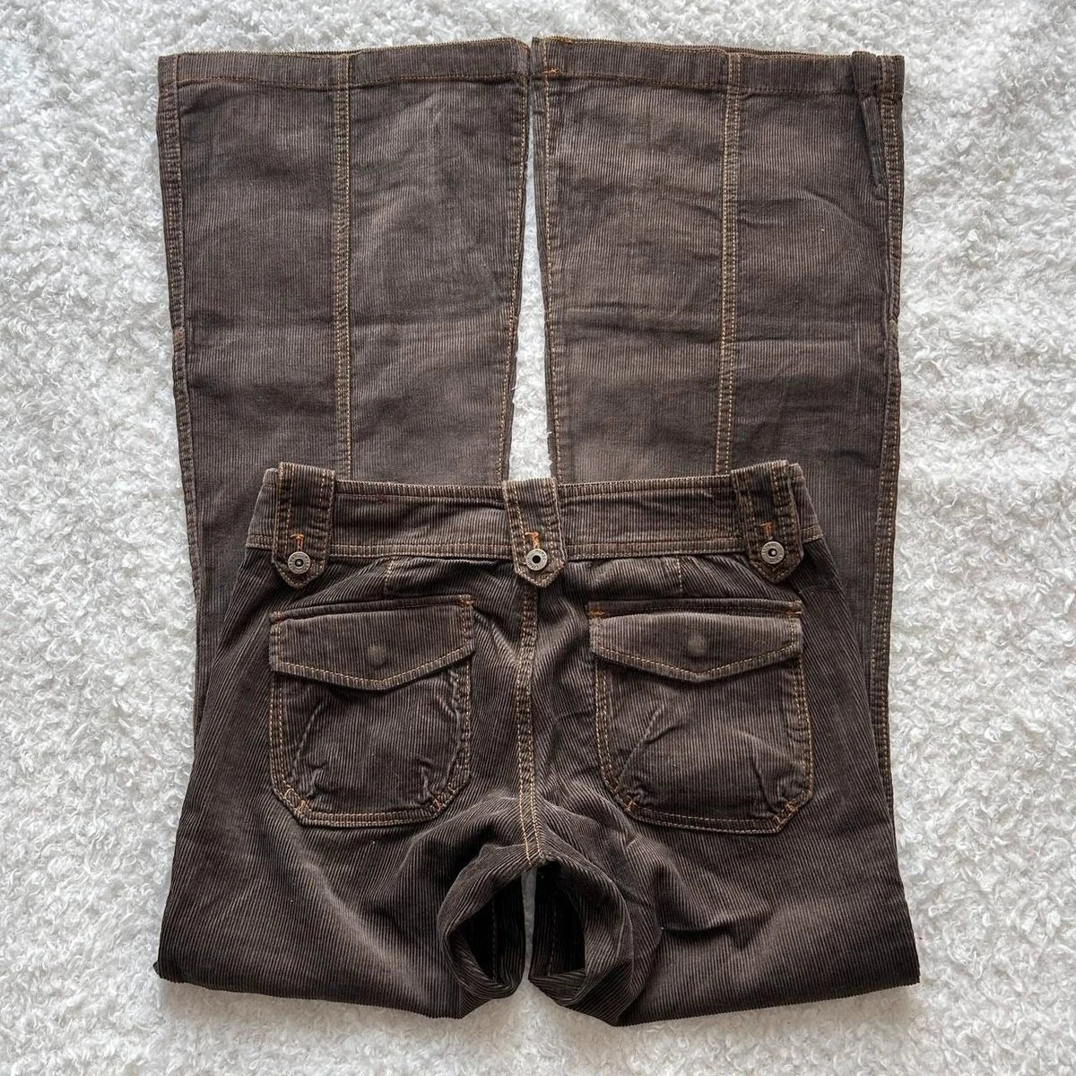 Y2K brown flared jeans for women, low-rise denim trousers with goth retro style, multiple pockets, slim fit, and flared hem.