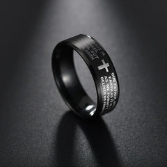 A black stainless steel ring featuring an engraved cross and Bible prayer text.
