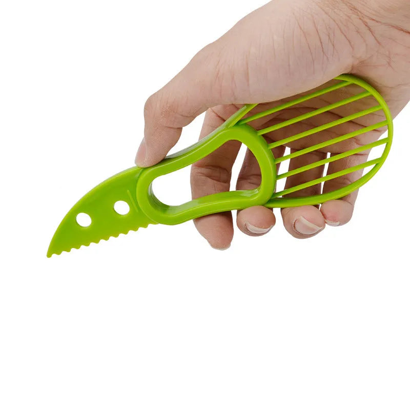 Showlu Fashion Store 3 in 1 avocado tool with slicer, pitter, and peeler, shown in a close-up image with green avocado slices.