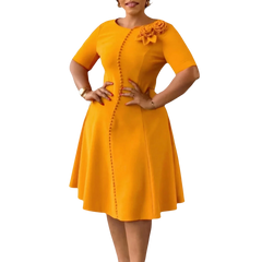 A mustard yellow A-line knee-length dress with short sleeves, a round neckline, and button detail.