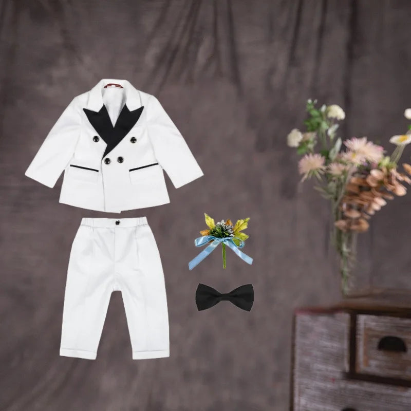 Children's white wedding suit with jacket, pants, and bowtie, perfect for flower boys and birthday parties by Showlu Fashion.