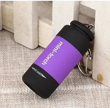 Showlu portable LED micro flashlight on keychain, USB rechargeable pocket-sized light with compact design and bright illumination.