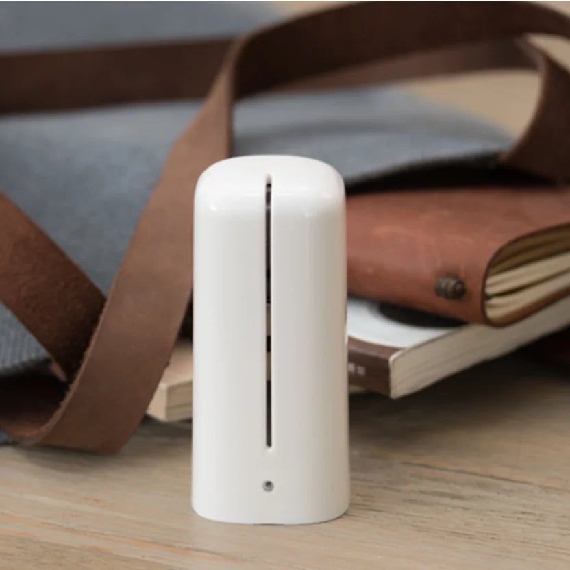 Portable Showlu Smart General odor eliminator device emitting a fresh scent in a modern home setting.