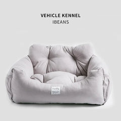 A light gray, plush pet car seat with a soft, cushioned interior and a small brand label.
