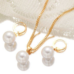 A gold-toned necklace with a pearl pendant and matching pearl hoop earrings on a white background.