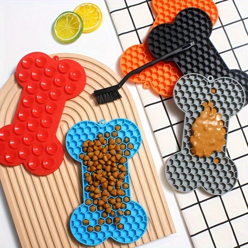 Silicone dog slow food pad with bone design, pet licking mat for dogs and cats, used on feeding placemats for pet enrichment.