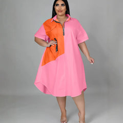 A plus-size woman wears a loose pink and orange color-blocked shirt dress with a front zipper.