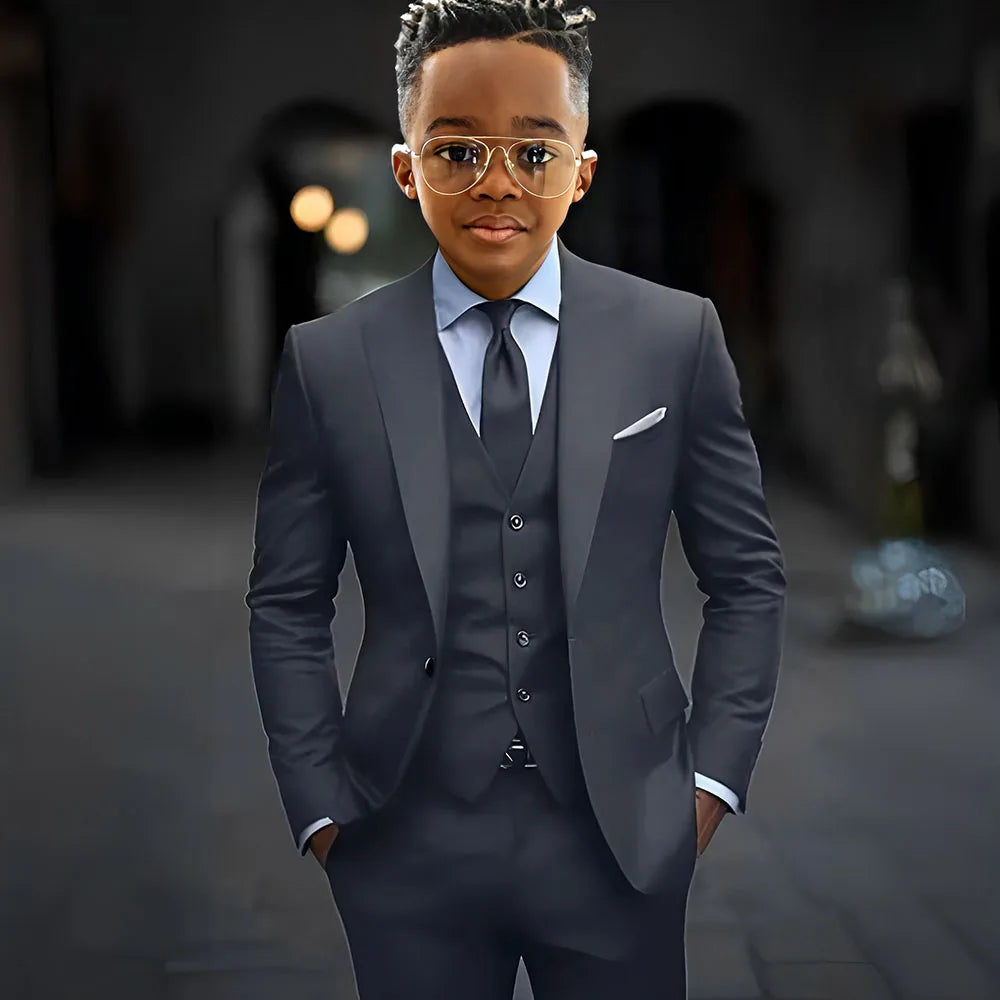 Dark grey high-quality boys’ 3-piece suit with slim fit, single-breasted jacket, peak lapel, pants, and vest by Showlu Fashion.