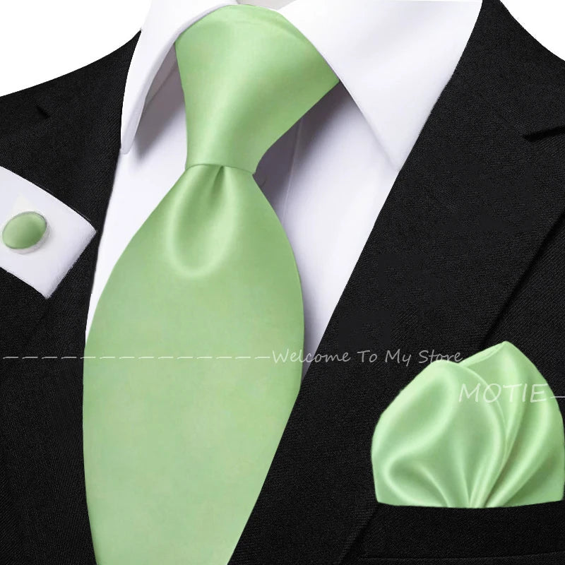 Men's solid green tie set with sage green pocket square, flower brooch, cufflinks, and collar accessory for wedding or daily wear.