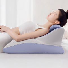 A woman rests on a grey and blue memory foam wedge pillow designed for back and neck support.