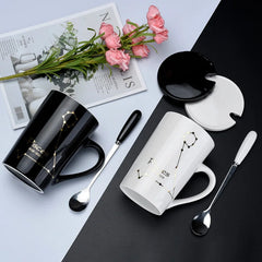 Two Pisces zodiac ceramic mugs, one black and one white, each with a matching lid and spoon.