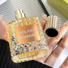 A square glass perfume bottle with a textured rivet pattern and a matching gold cap.
