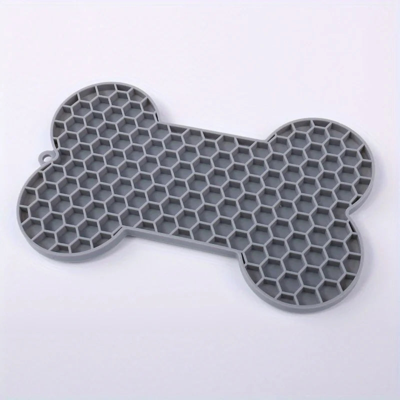 Silicone dog licking pad with bone shape for slow feeding, suitable for dogs and cats, designed to keep pets engaged during feeding.