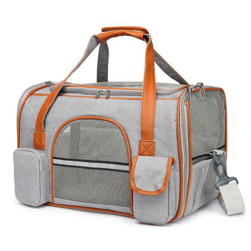 A grey soft-sided pet carrier with brown trim, mesh windows, and a shoulder strap.