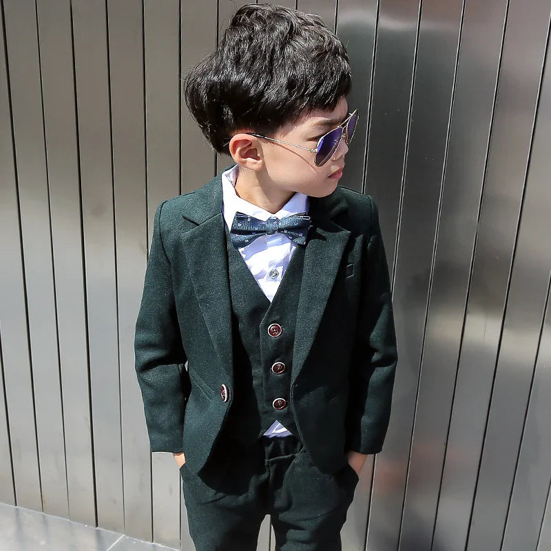 Dark green boys' formal wedding suit and tuxedo set by SHOWLU FASHION STORE, includes jacket, pants, vest, and shirt.