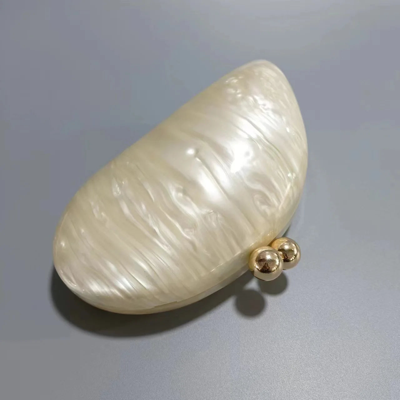 Blue acrylic shell-shaped clutch bag for women, designer evening party purse with pearl details and elegant egg shape.