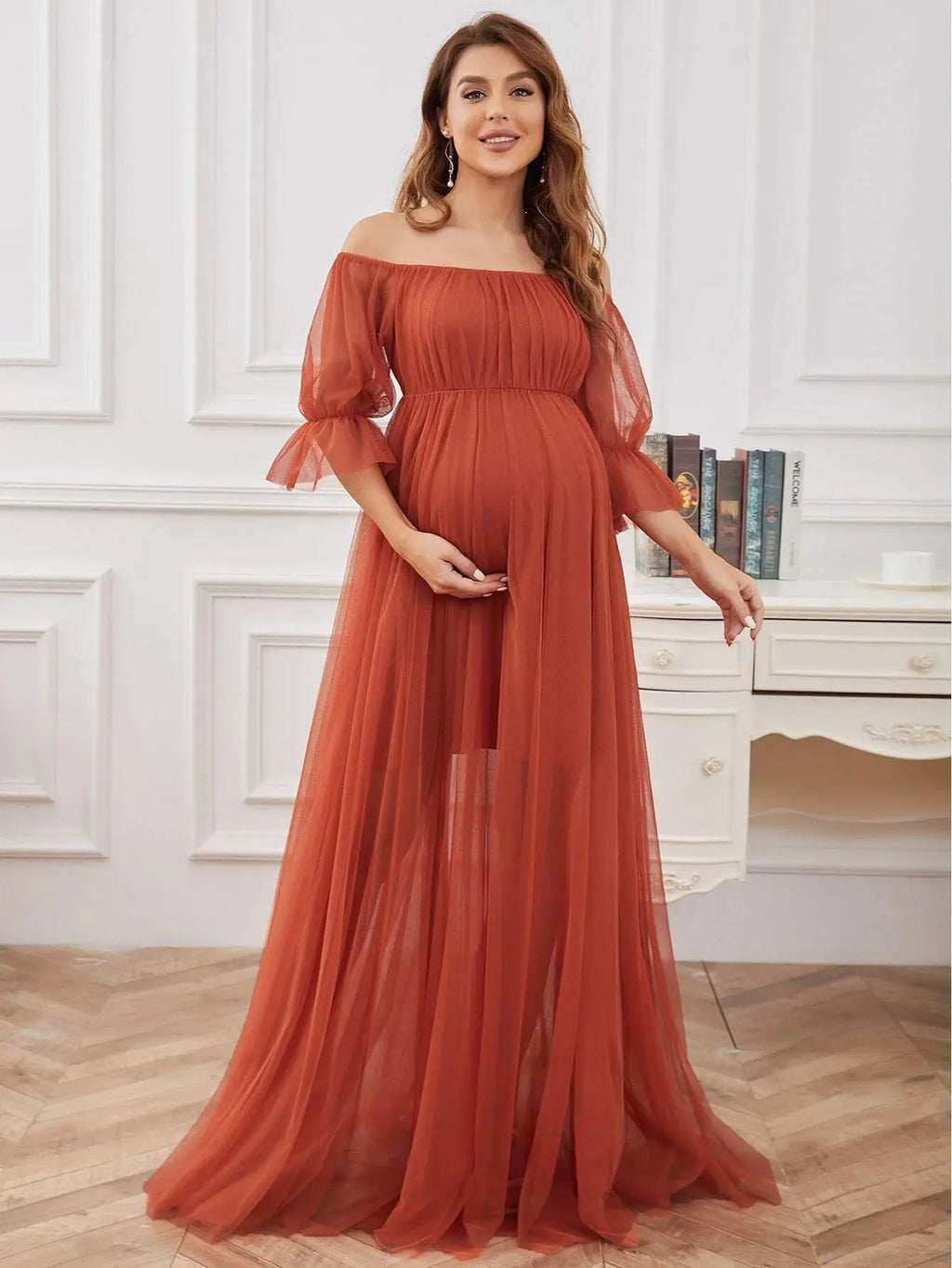 Off-shoulder tulle maternity dress with lace details, ideal for photoshoots, shown in a flowing, elegant style.