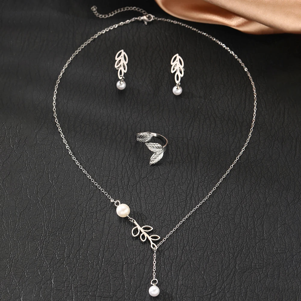 Stainless steel jewelry set with leaf design and pearls, including earrings, necklace, and adjustable leaf ring for women