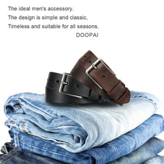Two leather belts with metal needle buckles rest on a stack of folded blue jeans.