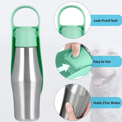 A stainless steel portable pet water bottle with a green integrated drinking bowl and handle.