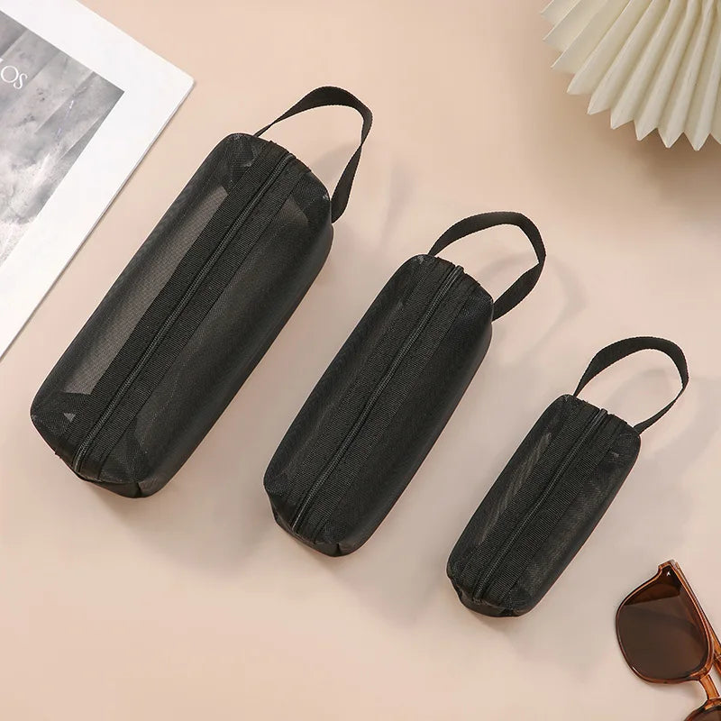 Large black travel cosmetic bag with mesh compartments, ideal for toiletries, makeup, and cosmetic storage.