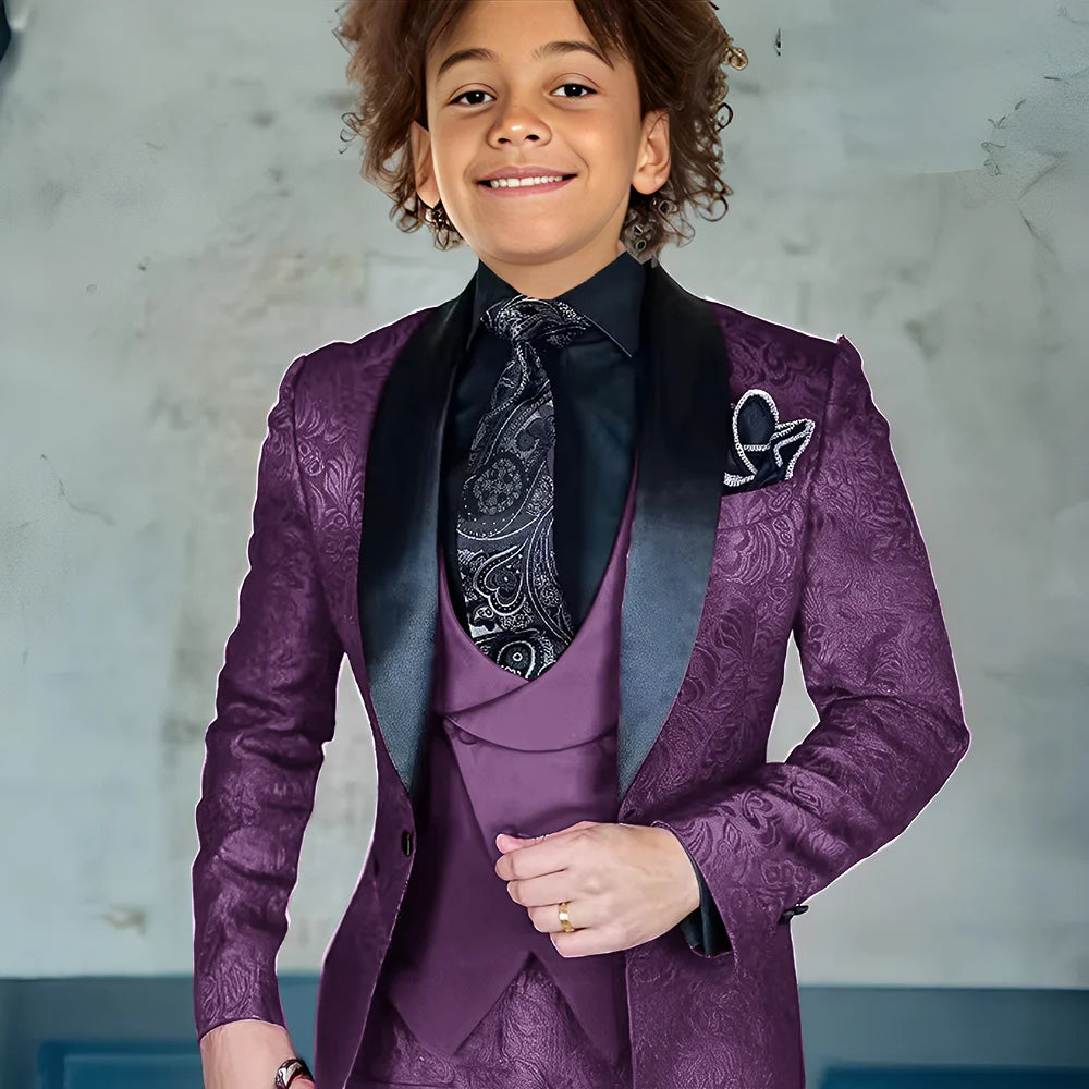 Burgundy three-piece boys' tuxedo suit with jacket, pants, and vest, formal slim fit style for weddings and special occasions.