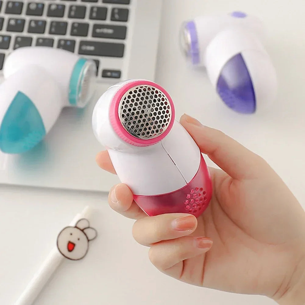 Electric lint remover fabric shaver by Showlu Smart General removing fuzz from a sweater for a smooth, clean fabric appearance.