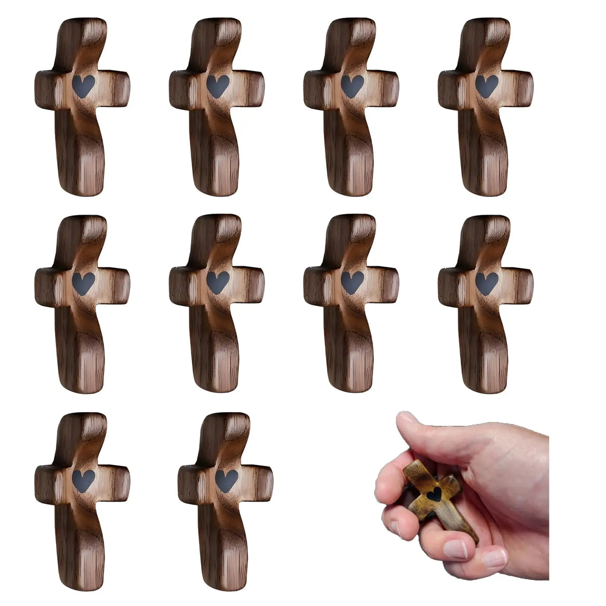 Ten small wooden pocket crosses with heart cutouts, including one held in a hand.