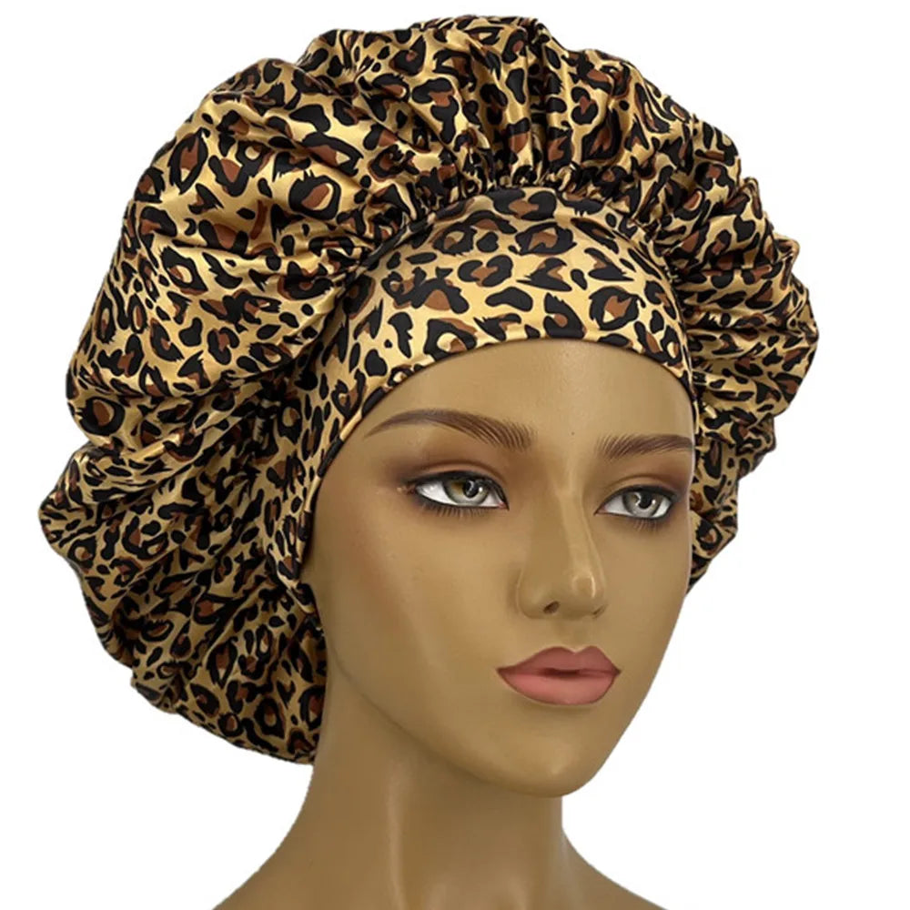 Leopard print satin sleep bonnet for women with wide elastic band, soft, curl-enhancing cap for dry and textured hair.