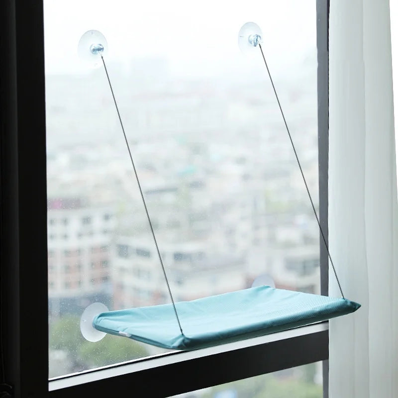 Showlu Smart General cat window hammock attached to a window, providing a cozy perch for cats to relax and enjoy the view.