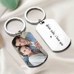 Two silver dog tag keychains, one featuring a photo of a couple and the other engraved with text.