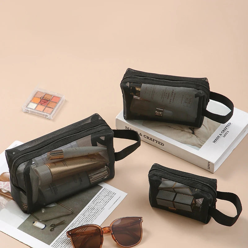 Large black travel cosmetic bag with mesh compartments for makeup and toiletries, ideal for organized cosmetic storage.